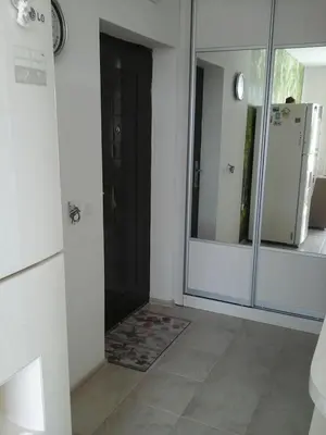 a bathroom with a mirror and a door with a refrigerator at Комплекс Конти in Ravda