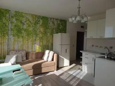 a living room with a couch and a kitchen at Комплекс Конти in Ravda