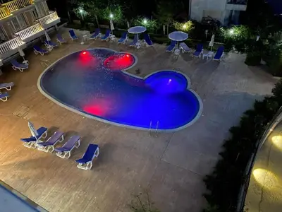 an empty swimming pool with chairs and tables at Студио Симона 5 първа линия море in Lozenets