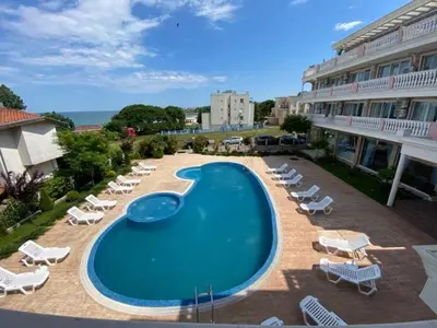 a swimming pool with lounge chairs and a hotel at Студио Симона 5 първа линия море in Lozenets