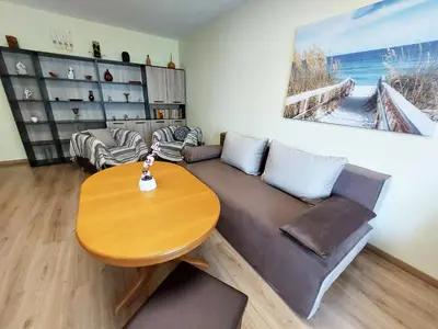 a living room with a couch and a wooden table at Апартамент за гости , жк. Зорница, бл.36 in Burgas City