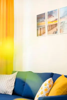 a couch with pillows and a painting of a beach at Cozy Home Santa Marina Sozopol in Sozopol