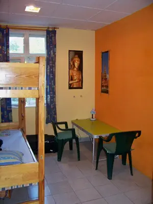 a room with a bed and a table and chairs at Yo Ho Hostel in Varna City