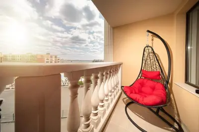 a swing on a balcony with a view of the ocean at Stylish Sea View Apartment 3 Min to Beach Balcony & Comfort in Pomorie