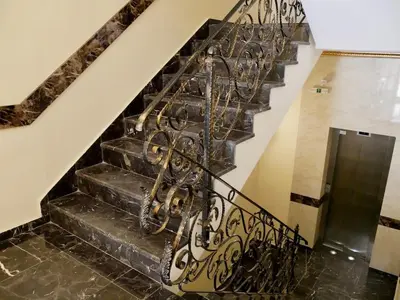 a set of stairs with a wrought iron railing at Stylish Sea View Apartment 3 Min to Beach Balcony & Comfort in Pomorie