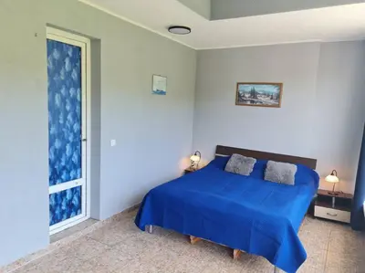 a bedroom with a blue bed and a window at Imperial Fort Club Apartament in Sveti Vlas