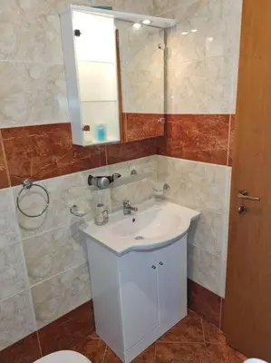 a bathroom with a white sink and a mirror at Imperial Fort Club Apartament in Sveti Vlas