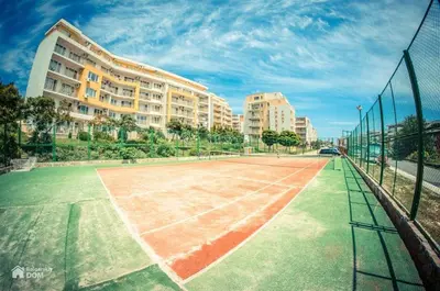 a tennis court in front of a building at Imperial Fort Club Apartament in Sveti Vlas