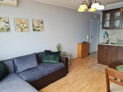 a living room with a couch and a kitchen at Imperial Fort Club Apartament in Sveti Vlas