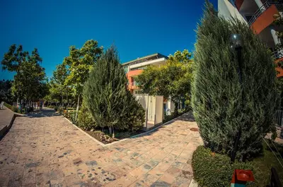 a cobblestone street with trees and a building at GT Green Fort Beach Apartments in Sunny Beach