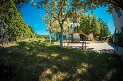 a playground with a slide in the grass at GT Green Fort Beach Apartments in Sunny Beach