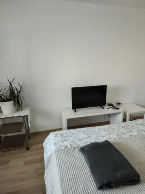 a bedroom with a bed and a flat screen tv at Sea apartment Lazur - next to the beach in Burgas City