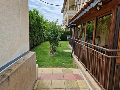 a balcony of a house with a yard with a tree at Aqua Dreams A4, Sveti Vlas , A much sought after complex. in Burgas City