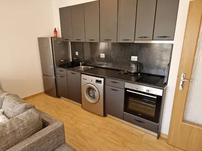 a kitchen with a stove and a washing machine at Aqua Dreams A4, Sveti Vlas , A much sought after complex. in Burgas City