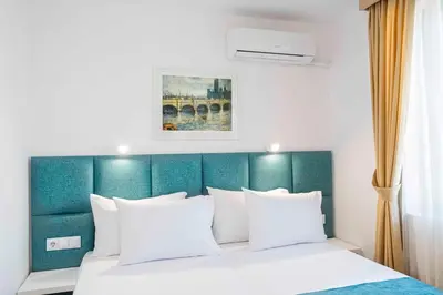 a bedroom with a bed with a green headboard at Електра Апарт Бургас Electra Apart Burgas Elektra Bourgas in Burgas City
