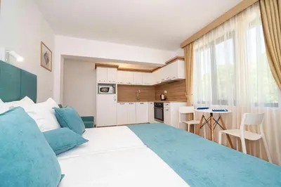 a bedroom with a large bed and a kitchen at Електра Апарт Бургас Electra Apart Burgas Elektra Bourgas in Burgas City