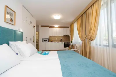 a bedroom with a large bed and a kitchen at Електра Апарт Бургас Electra Apart Burgas Elektra Bourgas in Burgas City