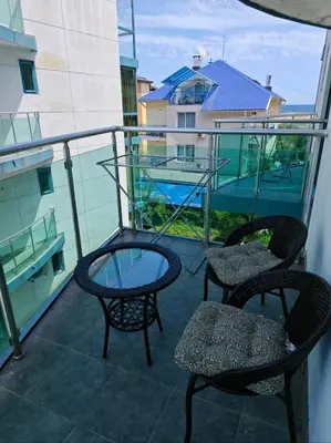 a balcony with two chairs and a glass table at Sunny Cozy Apartment Primorsko in Primorsko