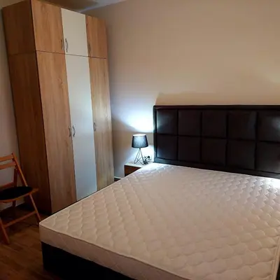 a bedroom with a bed and a cabinet and a lamp at Dream Cascadas - Слънчев бряг in Sunny Beach
