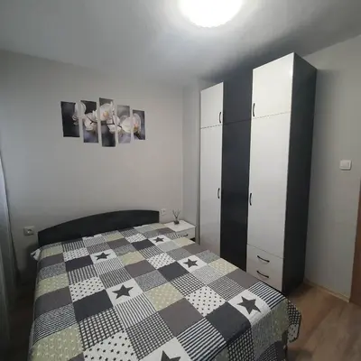 a bedroom with a bed with a black and white comforter at Apartment Voivoda in Varna City