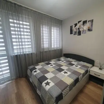 a bedroom with a bed with a black and white quilt at Apartment Voivoda in Varna City