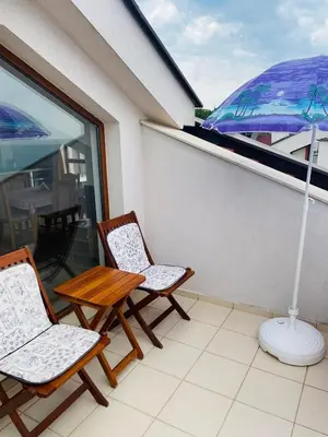 a balcony with two chairs and a table and an umbrella at Вила Дафни - Villa Dafni in Sozopol
