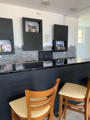 a bar with two chairs and a counter with two monitors at Sozopoli Hills Apartment А4 in Sozopol