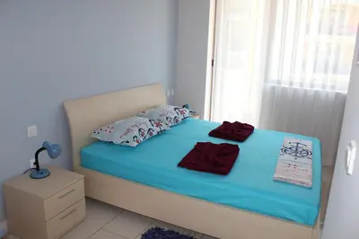 a bedroom with a bed with blue sheets and pillows at Private Apartments in Yoo Bulgaria Complex in Obzor