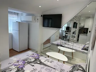 a room with a kitchen with a refrigerator and two chairs at Lovely studio in Burgas in Burgas City