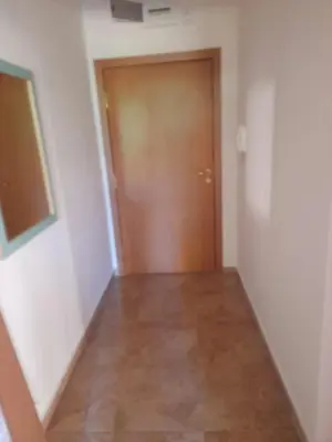 a hallway with a brown door and a wooden floor at YASSEN APARTMENT CLOSE TO SEA And Central in Sunny Beach