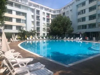 a swimming pool with lounge chairs and a building at YASSEN APARTMENT CLOSE TO SEA And Central in Sunny Beach