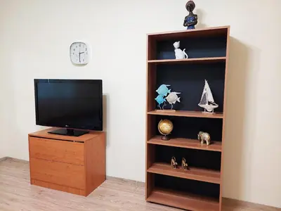 a entertainment center with a tv and a wooden book shelf at Апартамент за гости, ж.к. Зорница , бл.9 in Burgas City