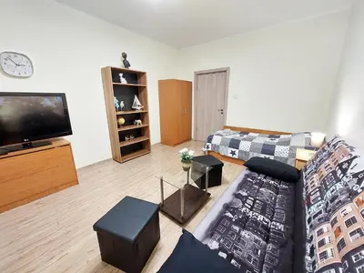 a living room with a couch and a flat screen tv at Апартамент за гости, ж.к. Зорница , бл.9 in Burgas City