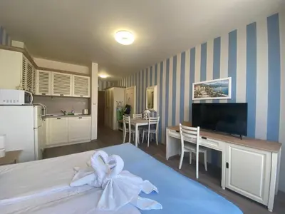 a room with a kitchen and a bed with a bow on it at PANORAMA BAY 20 Fancy Studio in Sveti Vlas