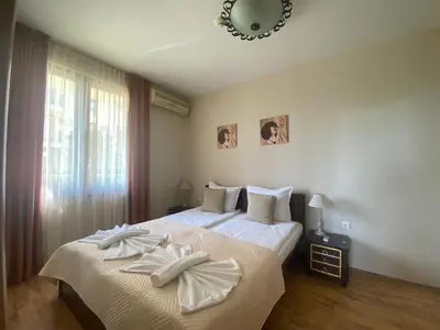 a bedroom with two beds with white sheets and a mirror at ROYAL BAY 6 Sea View Apartment in Sveti Vlas