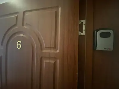 a wooden door in a room with a phone on the wall at ROYAL BAY 6 Sea View Apartment in Sveti Vlas