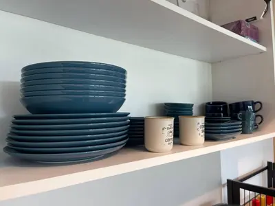 a stack of plates and cups on a shelf at Panoramic apartment in Varna with underground parking in Varna City