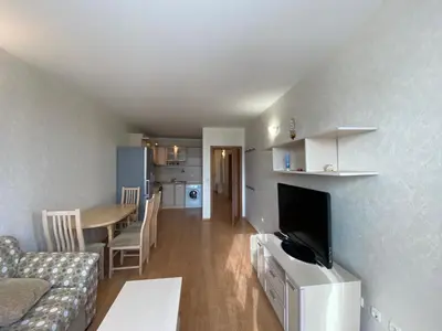 a living room with a couch and a table with a television at RUTLAND BEACH C8 Two Bedroom Apartment Ravda in Ravda