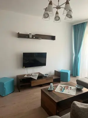 a living room with a flat screen tv and a coffee table at Deni's Apartment by the sea – Burgas in Burgas City