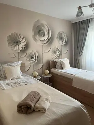 a bedroom with two beds and flowers on the wall at Deni's Apartment by the sea – Burgas in Burgas City