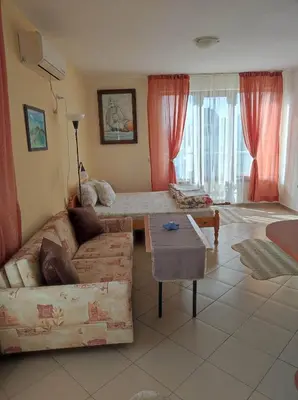 a living room with a couch and a table at Студио Слънчево утро in Burgas City