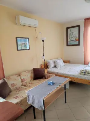 a living room with two beds and a couch at Студио Слънчево утро in Burgas City