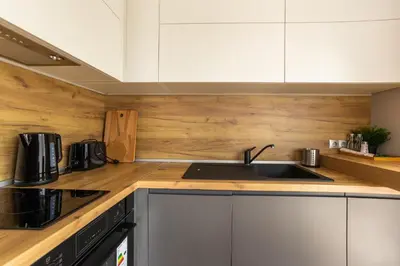 a kitchen with white cabinets and a sink at Open Sea Panorama Residence in Obzor