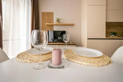 two wine glasses and a plate on a table at Open Sea Panorama Residence in Obzor