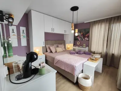 a bedroom with a bed and a purple wall at AMORE Obzor in Obzor