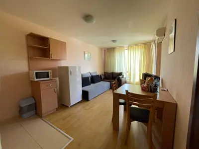 a kitchen and a living room with a couch and a table at Apartments in Panorama Beach Vigo Nessebar in Nesebar