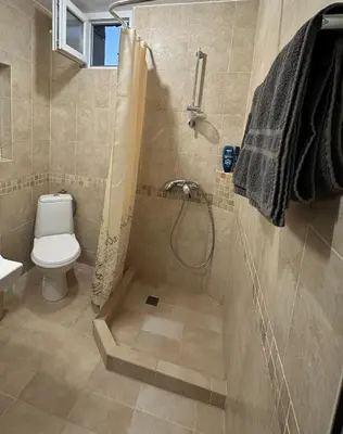 a bathroom with a shower with a toilet and a sink at Апартамент Joy in Varna City