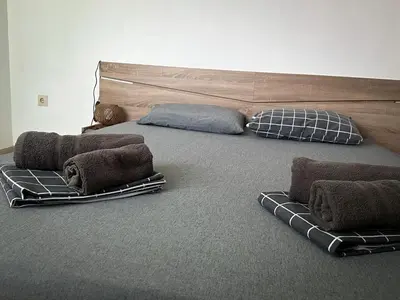 a bed with pillows on the floor in a room at Апартамент Joy in Varna City