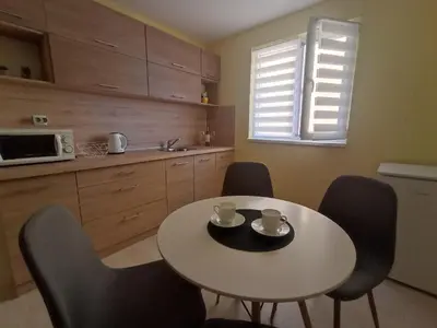 a kitchen with a table and chairs and a white table at Apartament Lili Sozopol in Sozopol