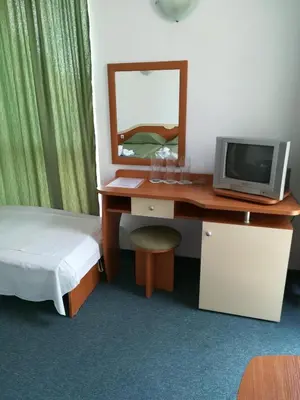 a bedroom with a desk with a computer and a mirror at Pension RUSKOVI GuestHouse in Ravda